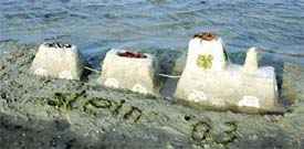 Skulptur aus Sand in Stein am Strand